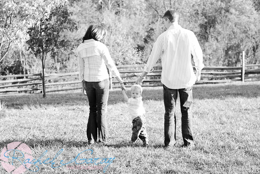 The family walks away from the camera in this outdoor photography!